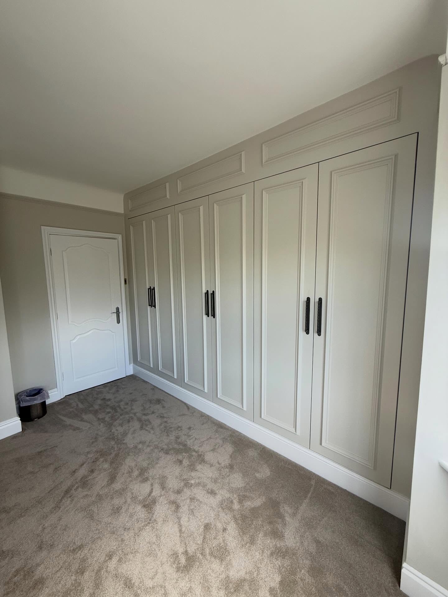 Cream fitted wardrobes painted in place